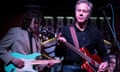 Antony Blinken with a red guitar performing on stage.