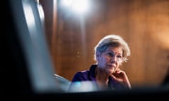 Older white woman, blond hair, glasses, rests left jaw in hand, appears to be listening intently.