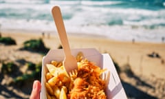 POV hand holding a box of Fish and Chips above Fistral Beach, Newquay, Cornwall on a sunny September day.<br>POV hand holding a box of Fish and Chips ( Cod and Chips )above Fistral Beach, Newquay, Cornwall on a sunny September day.