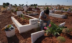 Syrian artist Aziz al-Asmar visits the grave of 13-year-old Hussein Sabbagh in Binnish. The teenager had helped Asmar with his political murals.