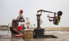 A boy collects drinking water from a hand pump, Kutubdia, Bangladesh.