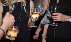 A group of people at a party holding wine glasses.
