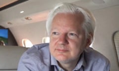 Julian Assange looking pensive in an airplane.