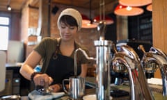 Barista pressing espresso with tamper in coffee shop