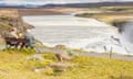 Gullfoss waterfall and two man on the wooden bench<br>Reykholt, Iceland - July 31, 2010: Two tourists on the wooden bench in background Gullfoss waterfall on Iceland. Gullfoss is one of the most popular tourist attractions in Iceland.