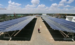 KENYA-AFRICA LARGEST-SOLAR<br>A man walks past solar panels at a solar carport on October 26, 2015 at the Garden City shopping mall in Nairobi. The roof-top solar carport, that was recently launched at the Garden City Mall is Africa's largest solar carport that will cut carbon emissions from power generation through non-renewable energy by 745 tonnes annually, with a total 3300 solar panels used that are capable of generating 1256 MWh annually. AFP PHOTO / SIMON MAINA / AFP / SIMON MAINA (Photo credit should read SIMON MAINA/AFP/Getty Images)