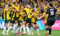 The matildas jump and hug each other in celebration as Mackenzie Arnold runs towards them