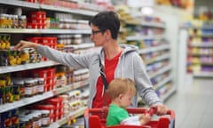 young mother with baby in shopping mall supermarket store buying food and grocery<br>F7CY3R young mother with baby in shopping mall supermarket store buying food and grocery