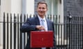 Jeremy Hunt poses for photographs as he leaves 11 Downing Street to deliver his budget to Parliament.