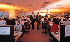 Two businessmen walking through busy office