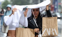 Shoppers on Oxford Street in London shelter from the July rain