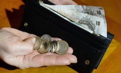 Someone holding a wallet with banknotes in it and some coins.