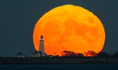 The lighthouse against a harvest moon backdrop.