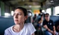 A woman sitting on a train in Bangkok, looking into the distance.