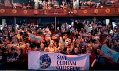 The theatre full of people, some holding banners saying 'save Oldham coliseum'