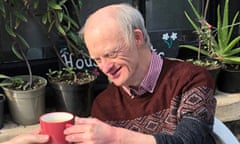 Marcus Hanlin smiling, taking a mug of tea from someone's hand