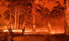 This timed-exposure image shows firefighters hosing down trees as they battle against bushfires around the town of Nowra in the Australian state of New South Wales