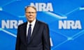 A man stands in front of signage for the NRA