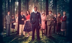 The cast of Murder is Easy standing ensemble in the midst of a forest, David Jonsson's Luke in the foreground, holding an umbrella. Other cast members are Dr Thomas (Mathew Baynton), Mrs Humbleby (Nimra Bucha), Rev Humbleby (Mark Bonnar), Lord Whitfield (Tom Riley), Bridget (Morfydd Clark), Miss Pinkerton (Penelope Wilton), Major Horton (Douglas Henshall), Rivers (Jon Pointing), Honoria Wayneflete (Sinéad Matthews) and Mrs Pierce (Tamzin Outhwaite).