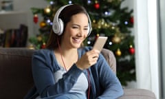 Happy woman wearing headphones listening to music at Christmas