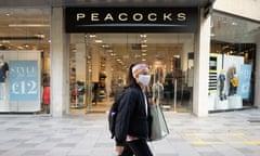 A woman wearing a face covering walks past a Peacocks store in Cardiff last month.