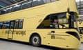 Greater Manchester mayor Andy Burnham looks out the driver's window on a double-decker yellow bus