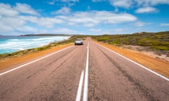 Car driving along road with ocean on the left