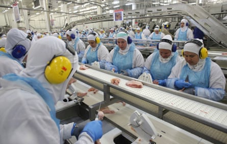 Workers prep poultry at the meatpacking company JBS, in Lapa, in the Brazilian state of Parana, in 2017.