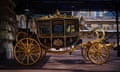 A gold and black carriage is on display.