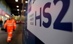 A worker walks past a sign outside a construction site for a section of Britain's HS2 high-speed railway project, at London Euston railway station in London on January 20, 2020.