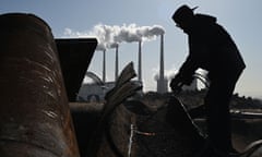 A worker using a torch to cut steel pipes.