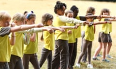 Girls wearing yellow t shirts line up and punch the air as part of a youth group boxing exercise.