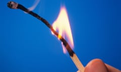 Close-up of man's hand holding a lit wooden match against a blue background. Image shot 1998. Exact date unknown.<br>AD64GW Close-up of man's hand holding a lit wooden match against a blue background. Image shot 1998. Exact date unknown.