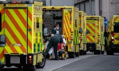 Paramedics take a patient from an ambulance into the Royal London Hospital