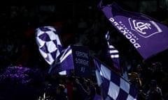 Fremantle Dockers fans waving flags at an AFL match