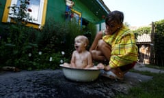 Ekaterina, a granddaughter of 75-year old Ekaterina Panchenya, bathes her daughter Dasha in a basin on a hot summer day in the village of Pogost, Belarus