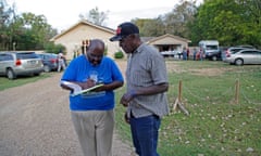 Eugene Keahey, left, pastor at Mount Zion Baptist church, gets a volunteer to start a sign-in sheet for people in need of basic supplies from the church located in Sandbranch, Texas.