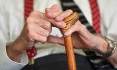 A close-up of an elderly man holding a walking stick