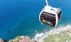 The new cable car at Fajã dos Padres. A car, viewed from above, makes its way down the cliff to the coast and blue sea shore below.