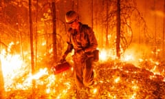 A firefighter from an Alaska smoke jumper unit uses a drip torch to set a planned ignition on a wildfire burning near a highway outside Vanderhoof in northern British Columbia, Canada on July 11, 2023. Planned ignitions like this help firefighters remove fuel between a main fire and a control line or guard built by hand, or with heavy equipment. Photo by Jesse Winter NOT FOR SYNDICATION
