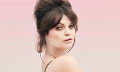 Pixie Geldof , dark hair gathered on top of her head, looking sideways to the camera, a black strap on her bare shoulder