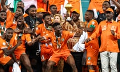 The president of Ivory Coast Alassane Ouattara (centre) lifts the Africa Cup of Nations trophy after Ivory Coast defeated Nigeria in this year’s final.