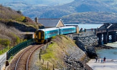 Arriva passenger train near Barmouth Bridge or Viaduct on the Mawddach Estuary in Gwynedd North Wales UK built in 1867. Image shot 2014. Exact date unknown.<br>EFJFXM Arriva passenger train near Barmouth Bridge or Viaduct on the Mawddach Estuary in Gwynedd North Wales UK built in 1867. Image shot 2014. Exact date unknown.