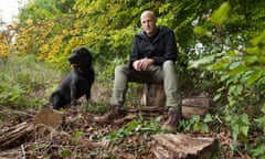 Zak Frost with his black labrador dog, Stanley, in woods in Wiltshire.