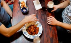 Seated customers with food and drink inside a Wetherspoon's pub