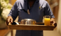 A care home worker carries a meal to a room