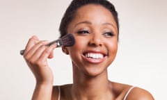 Lady laughing while applying blush brush on cheeks<br>one woman, studio, beautiful women, make up, personal care