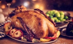 Traditional Christmas goose dinner with apples, Brussels sprouts and pudding