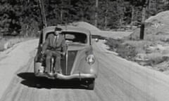 Man riding on front of car through National Parks