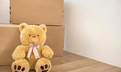 Teddy bear wooden floor alone cardboard boxes